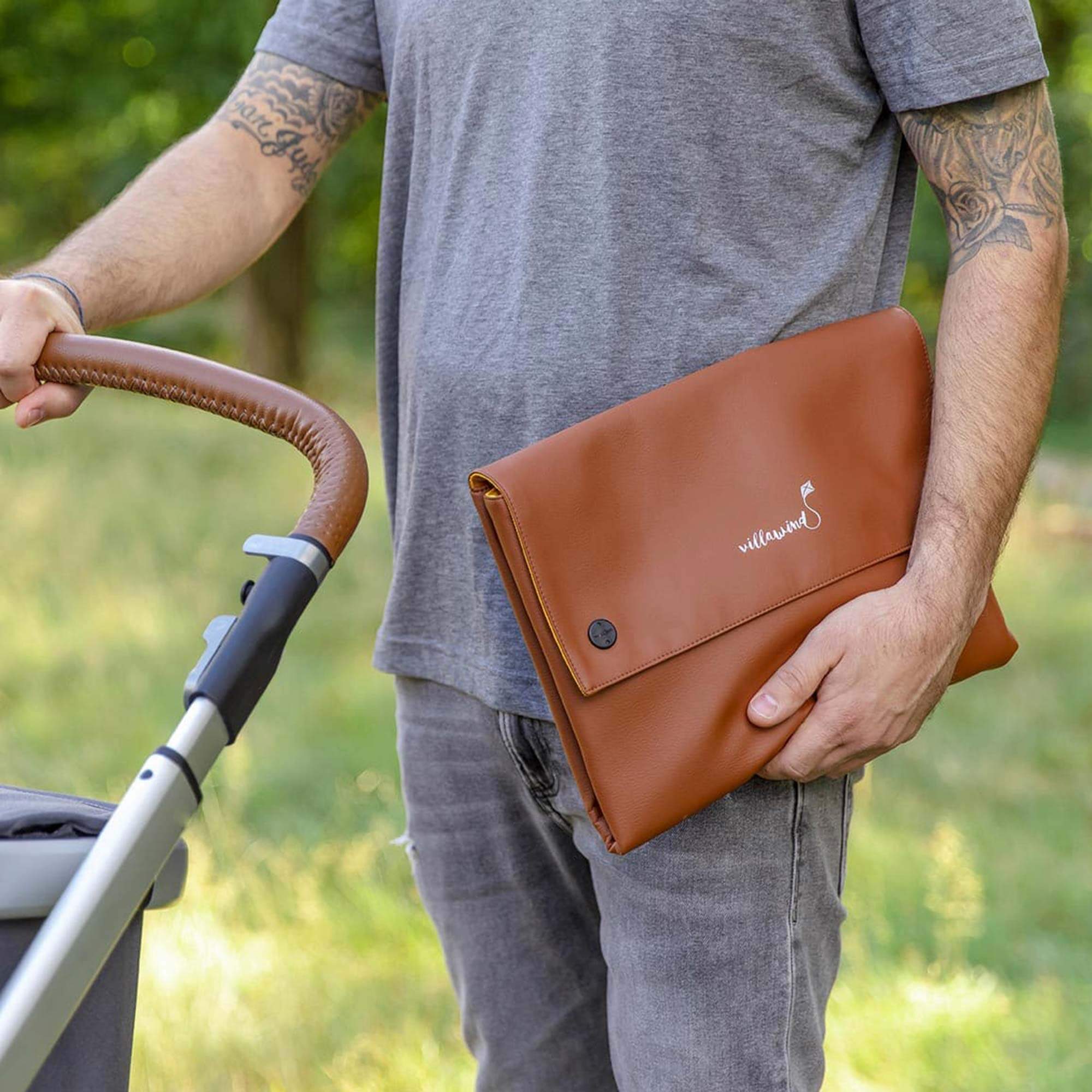 Villawind Wickeltasche faltbar in der Farbe Caramel getragen von einem Vater mit Kinderwagen