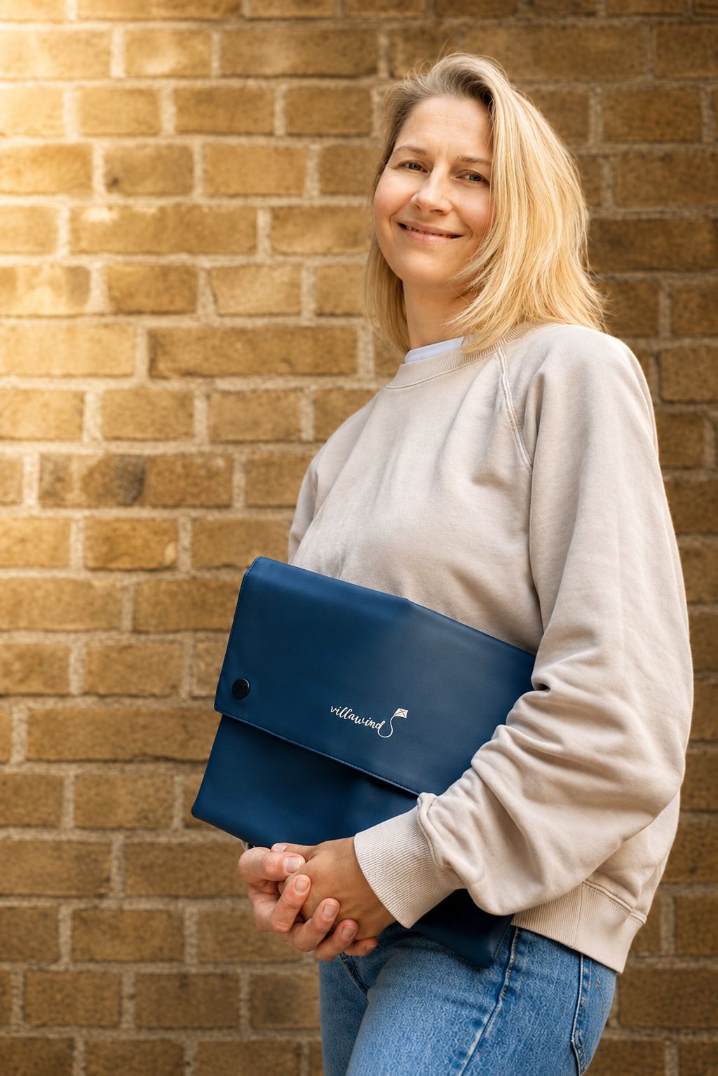 Gründerin von Villawind mit blauer, faltbarer Wickeltasche unter dem Arm